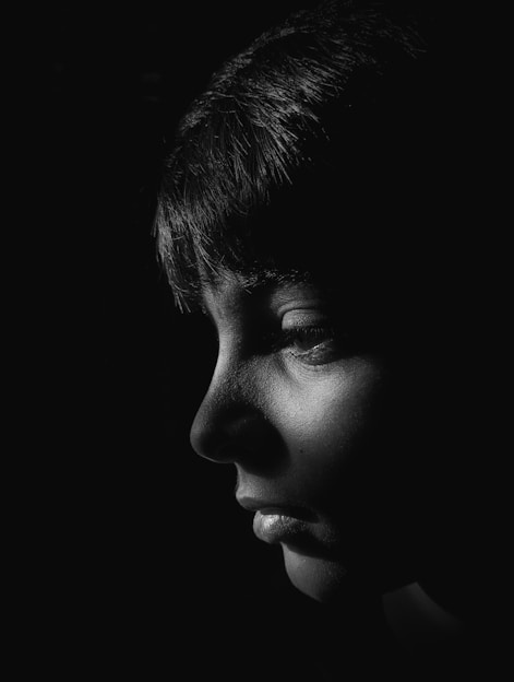 Black and white portrait of a model captured in natural light with strong contrast.