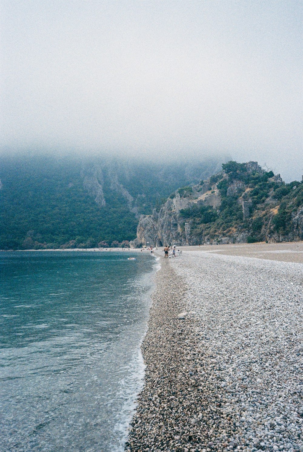 a beach with people walking on it