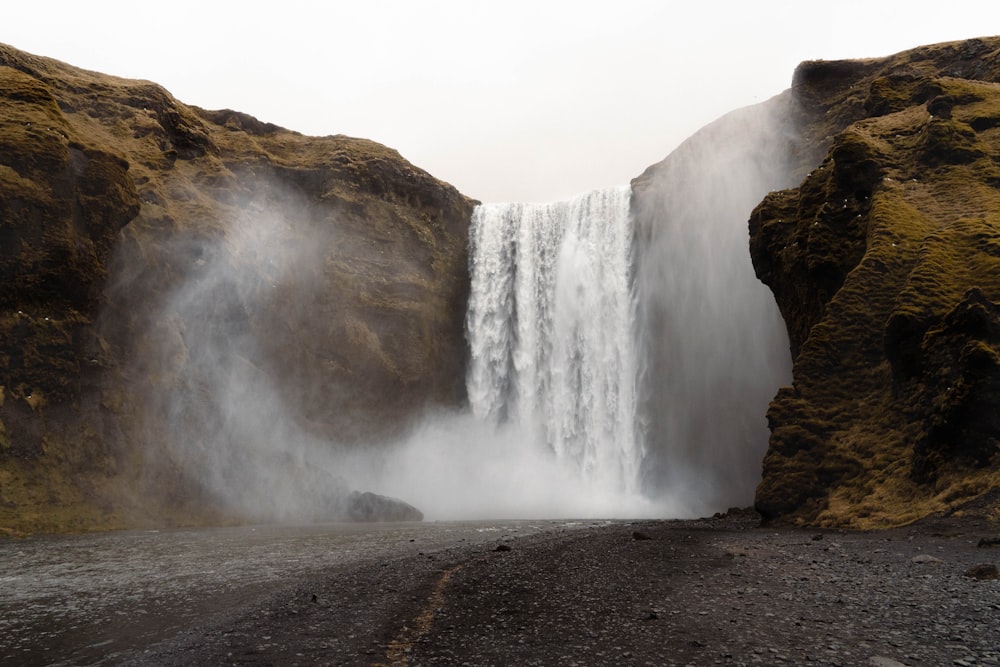 a waterfall with a cliff in the background