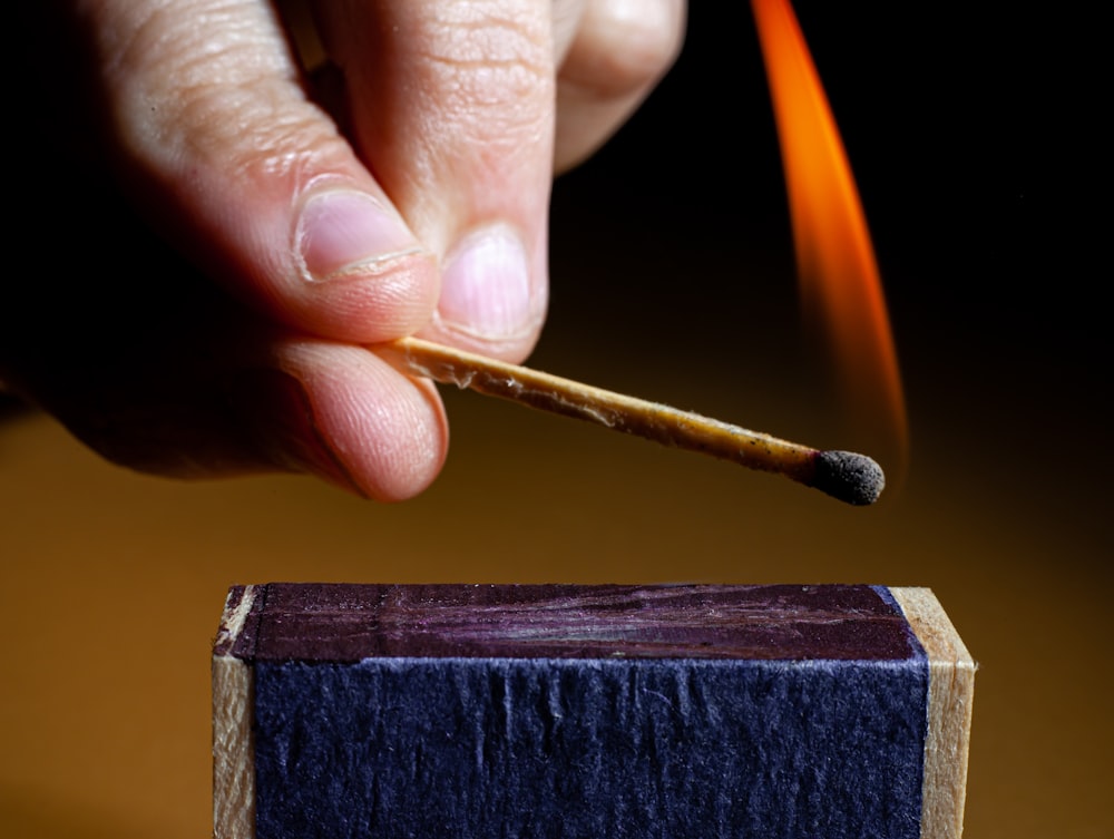 a person painting a blue piece of wood