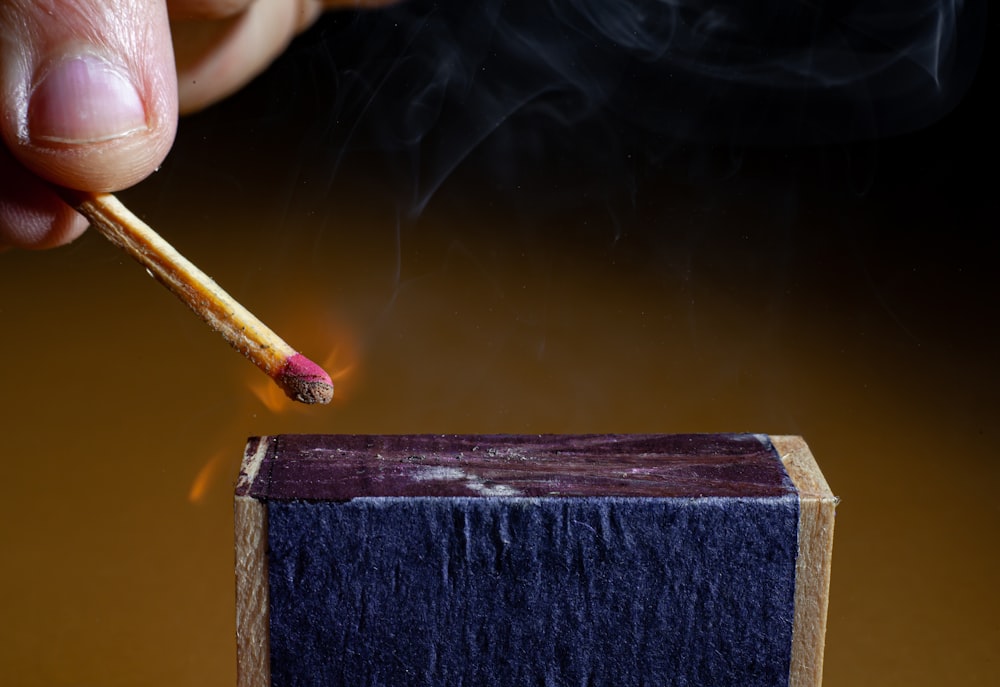 a person painting a blue piece of wood