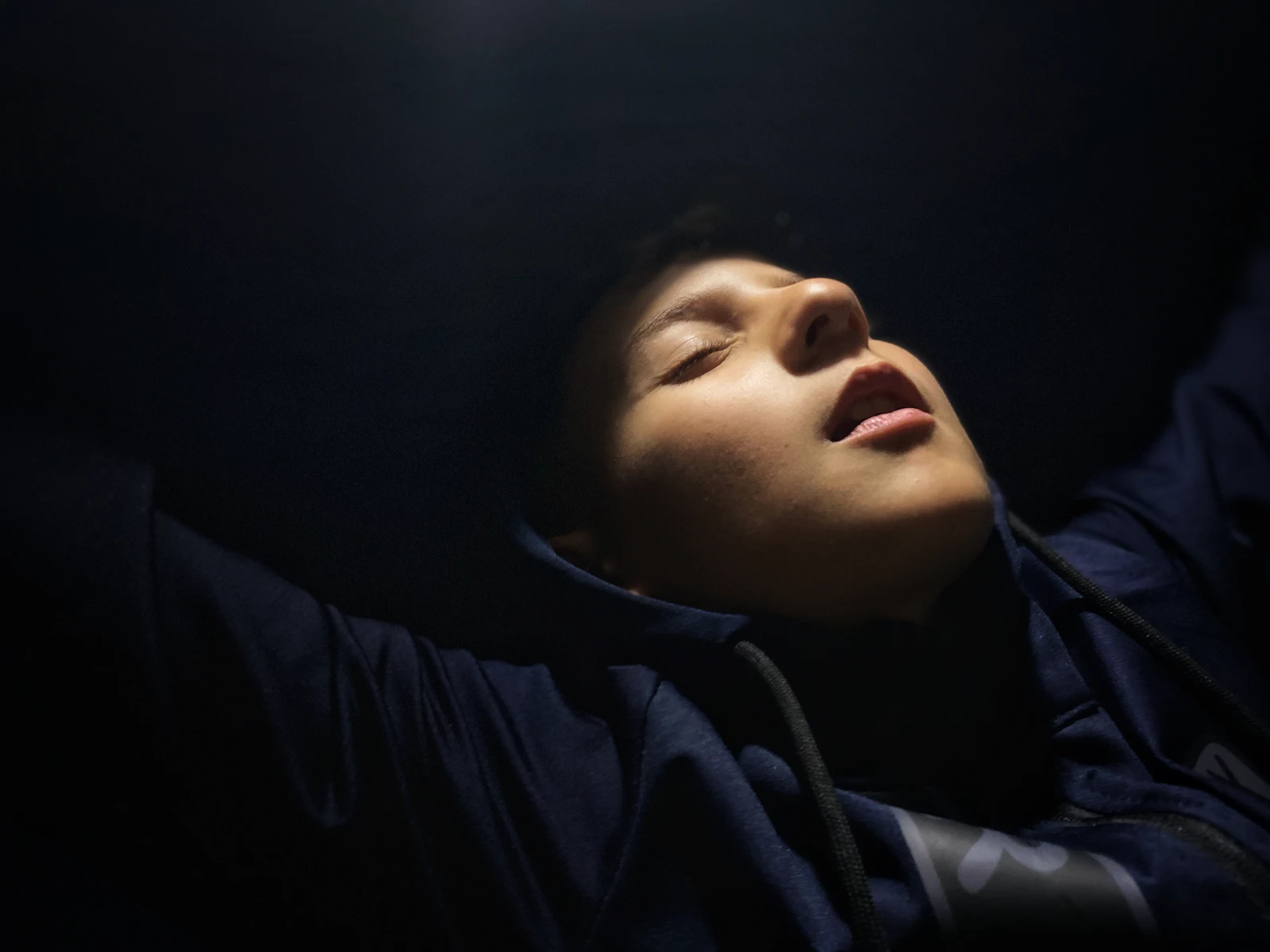 A person sleeping in a dark room