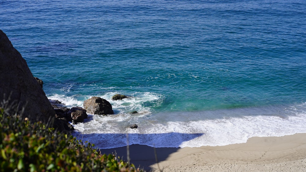 a beach with rocks and a body of water