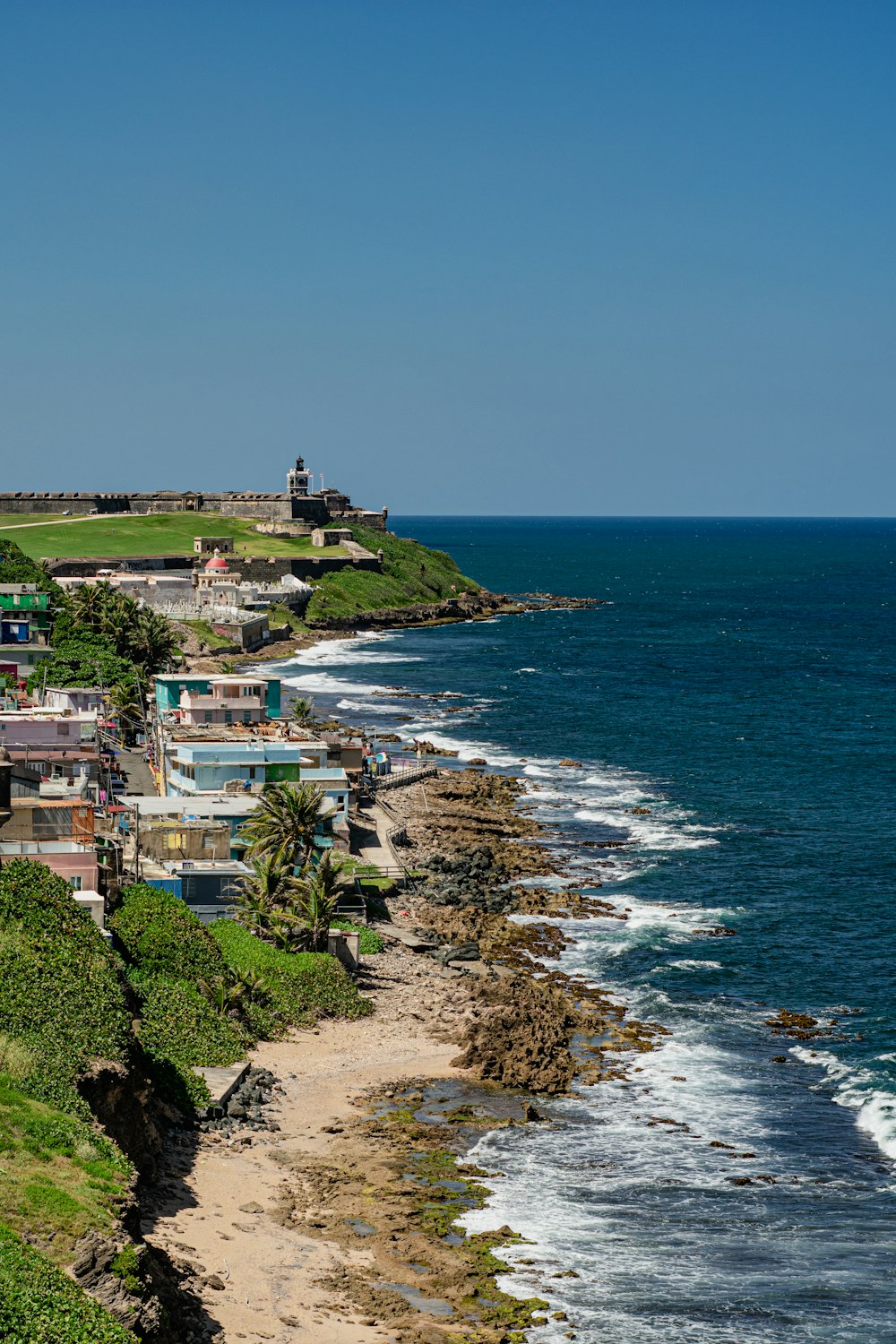 a beach with houses and trees by the water