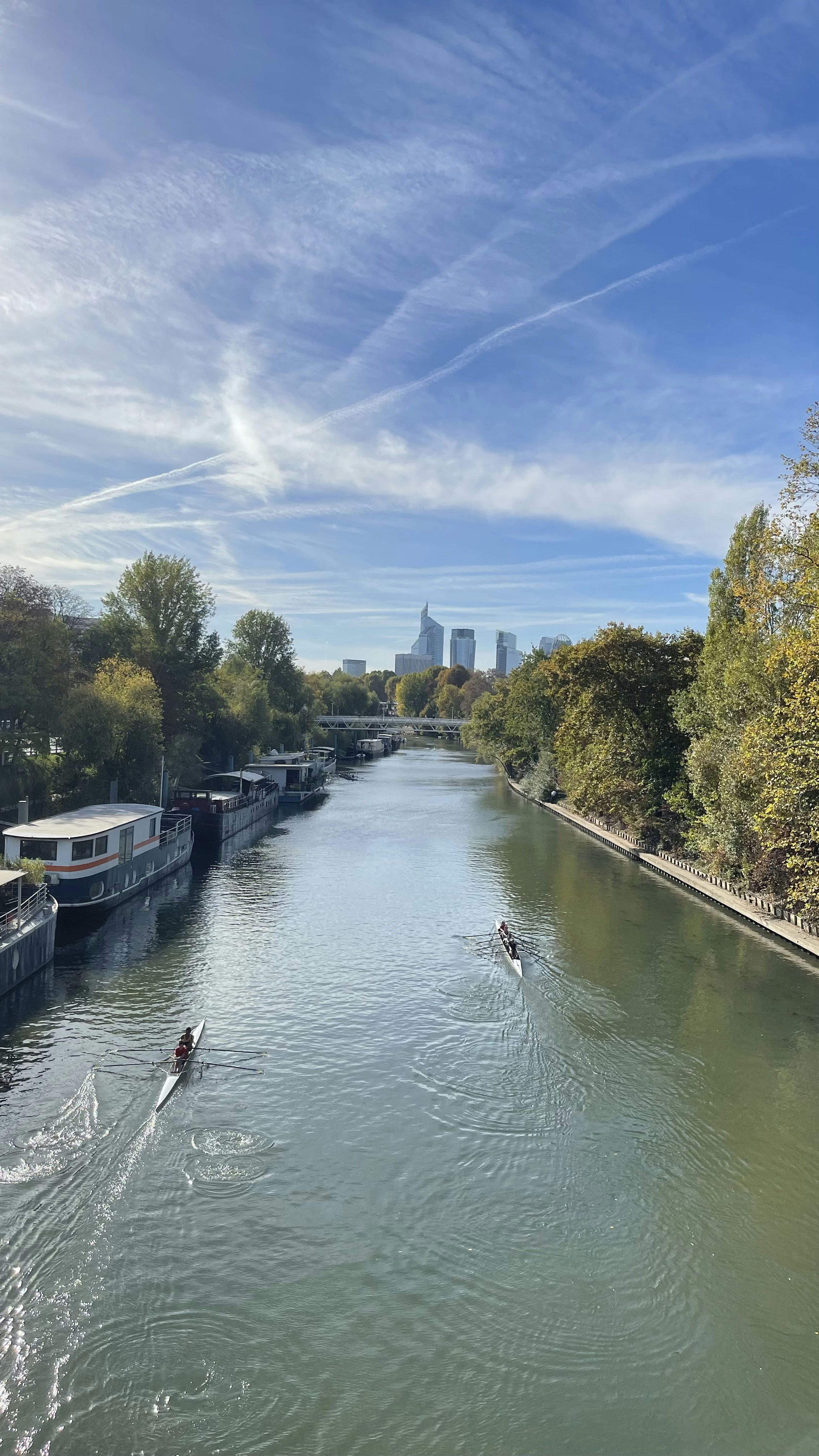 a couple of people in a boat on a river with a city in the background