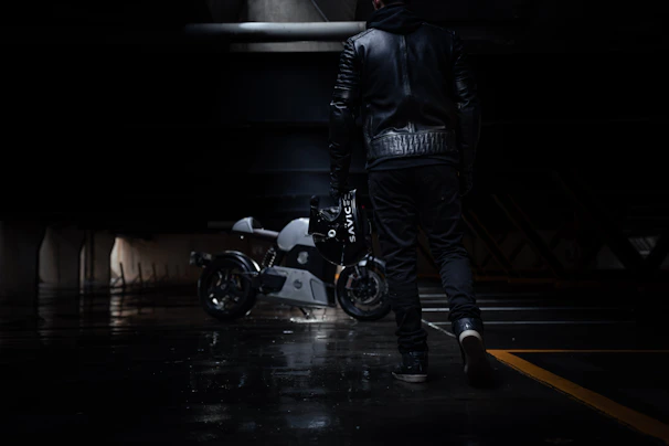 A cinematic shot of a man walking down a dimly lit urban street, clad in the urban rider jacket, exuding effortless confidence.