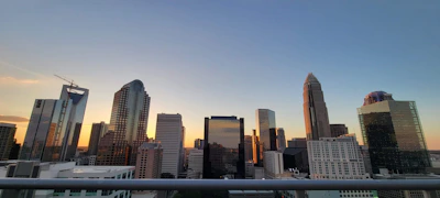 A modern city skyline with residential and commercial buildings at sunset