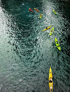A group kayaking down a sparkling blue river, splashing water and feeling alive.