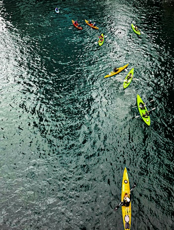 A group kayaking down a sparkling blue river, splashing water and feeling alive.