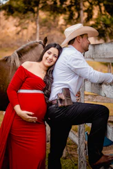 a man and woman posing for a picture with a horse