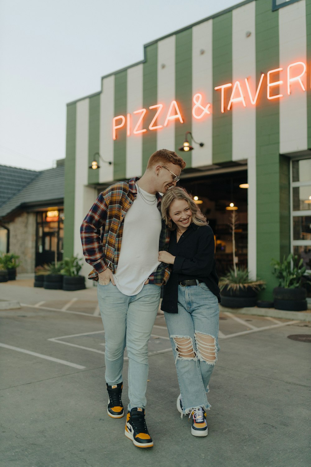 a man and woman posing in front of a building