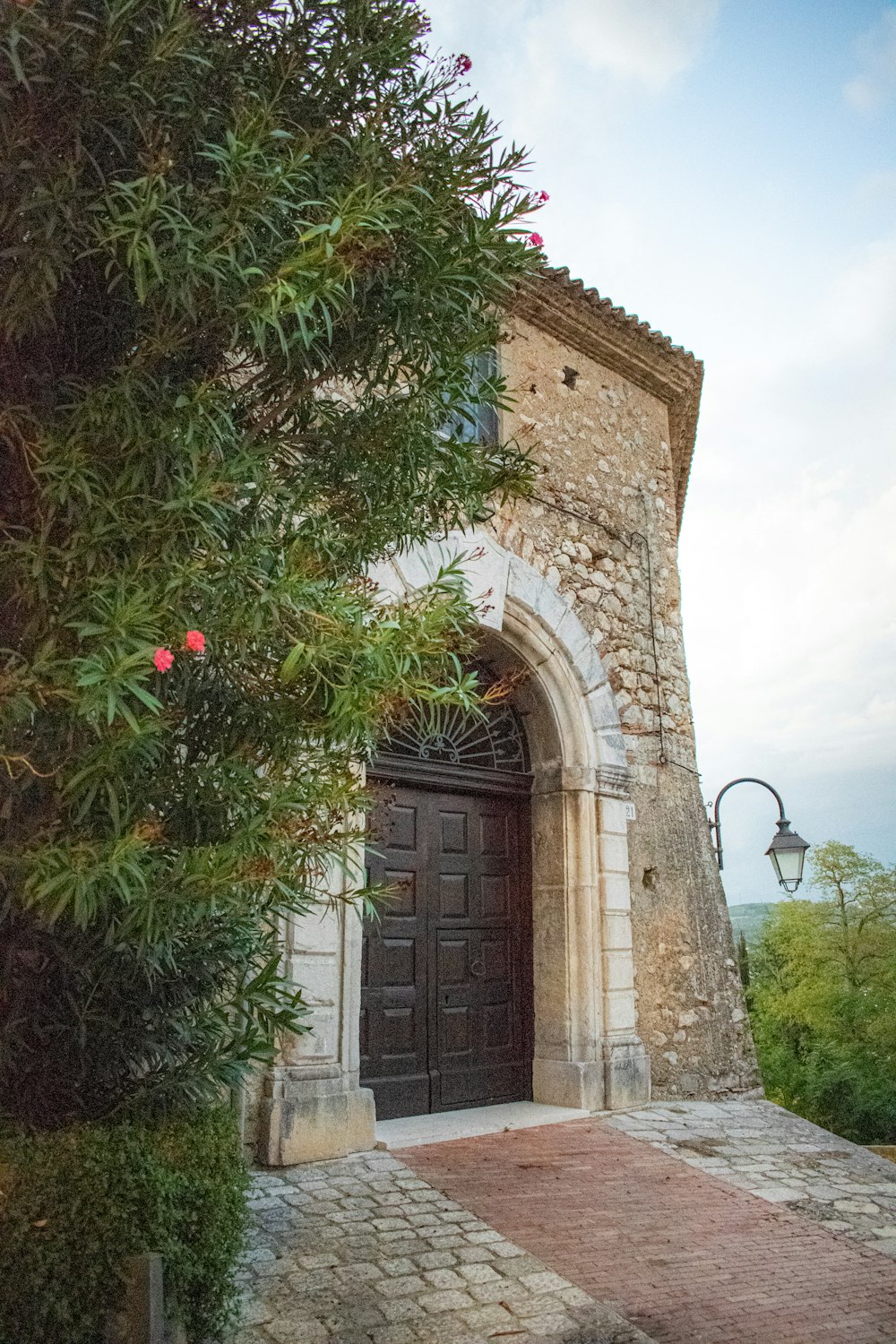 a stone building with a door and a tree in front of it