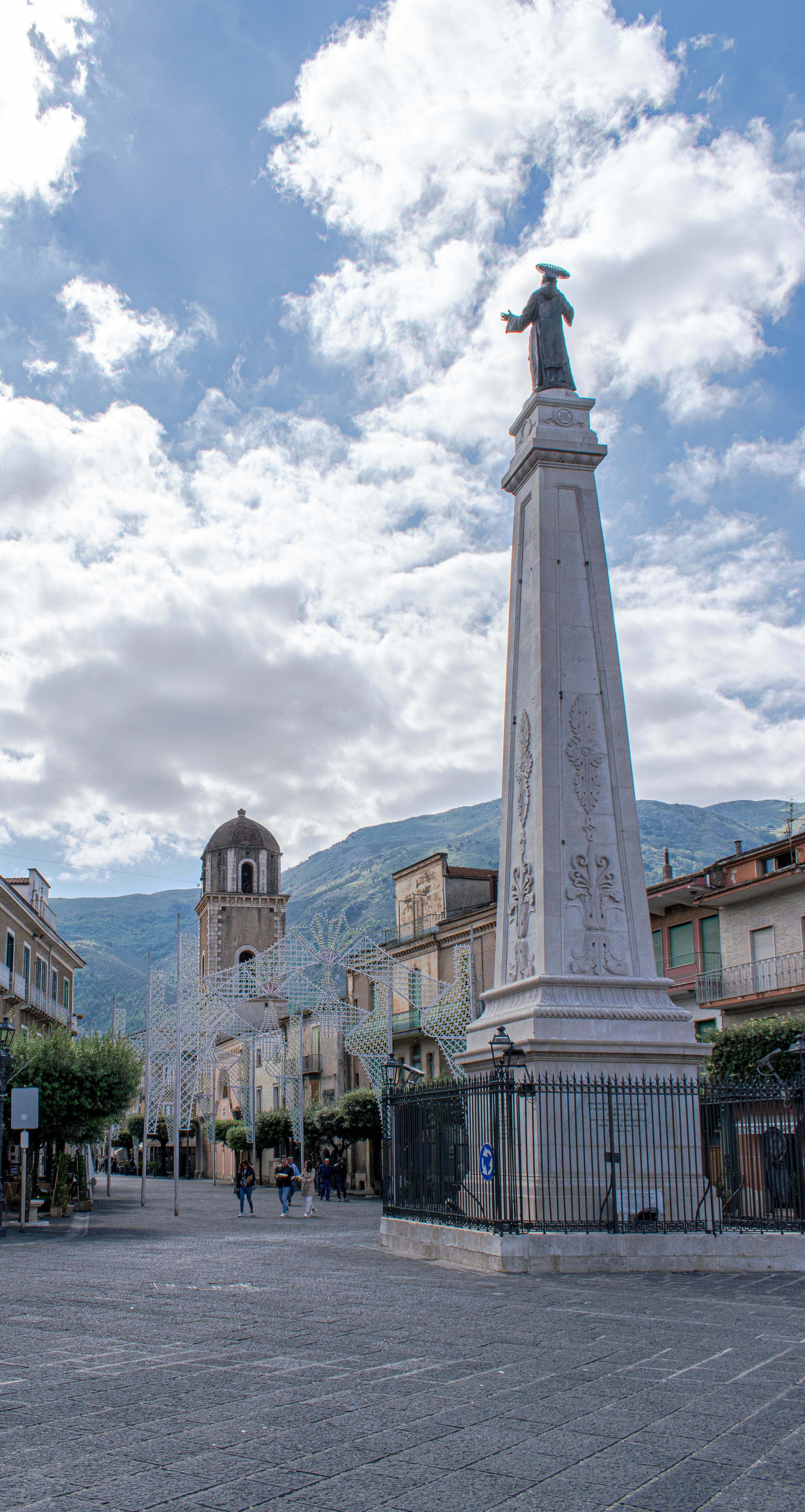 a statue of a person on a pedestal in a city