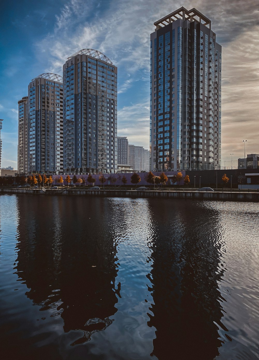 a group of tall buildings by a body of water