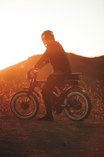 Close-up of a rider’s helmet and goggles, reflecting the fiery orange glow of the setting sun