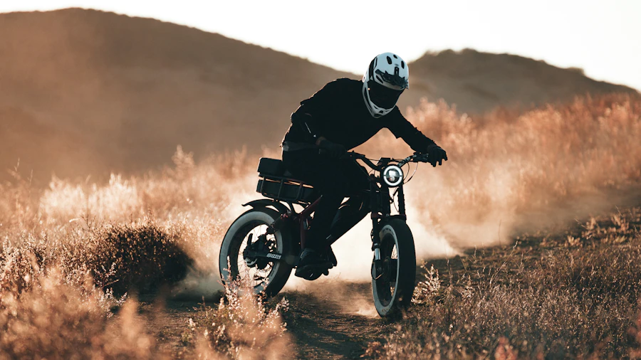 Rider on an electric dirt bike kicking up dust at sunset