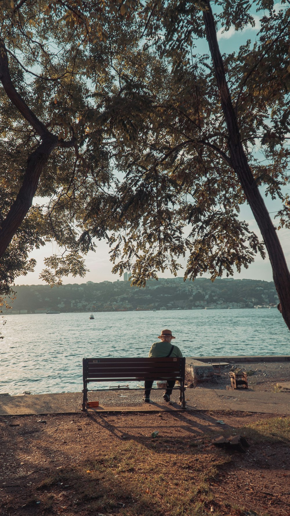 a person sitting on a bench by a lake