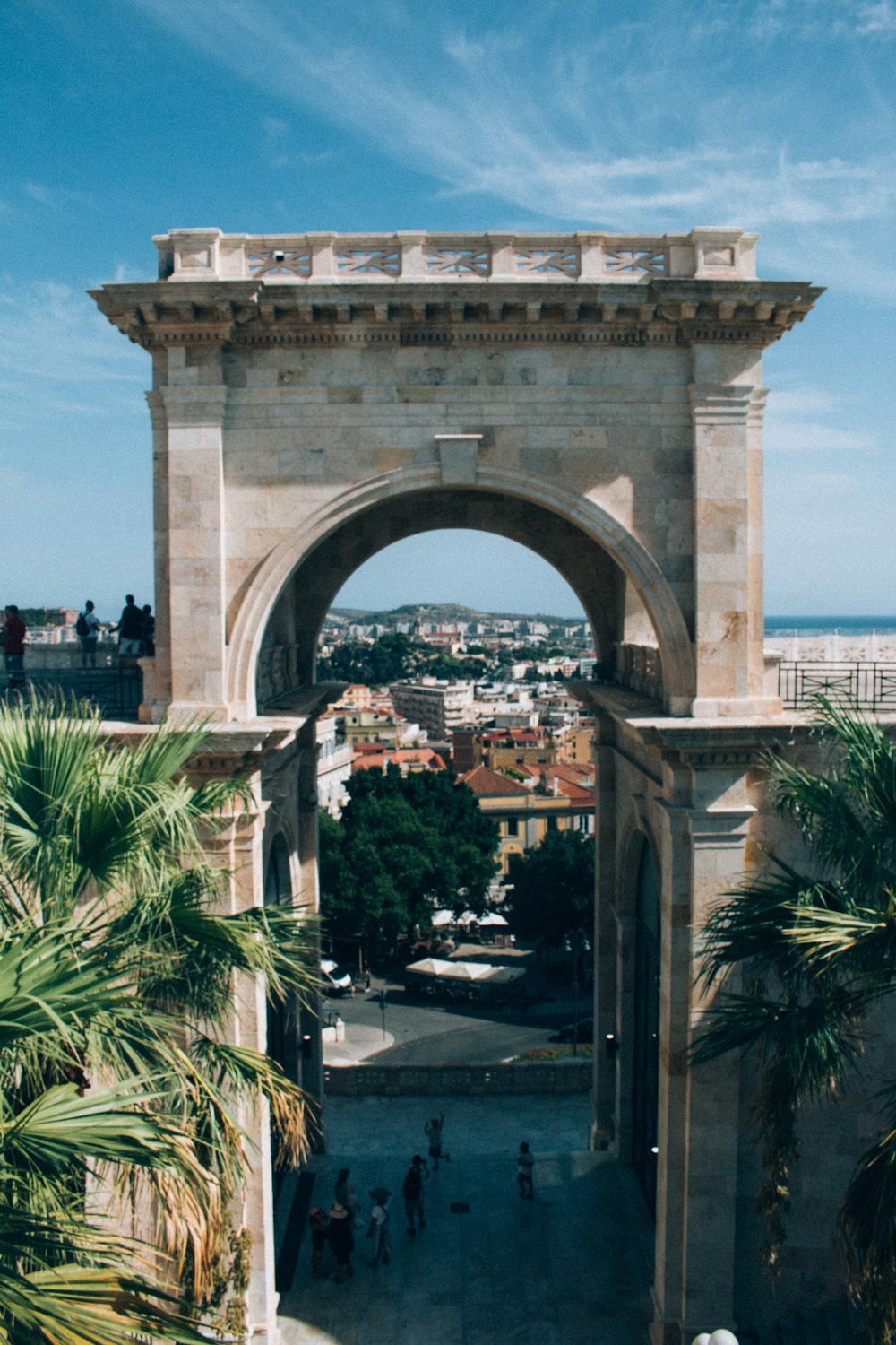 a large stone archway with people walking around