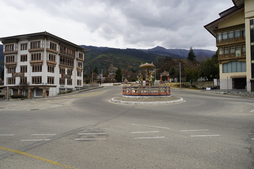 a parking lot with buildings and mountains in the background