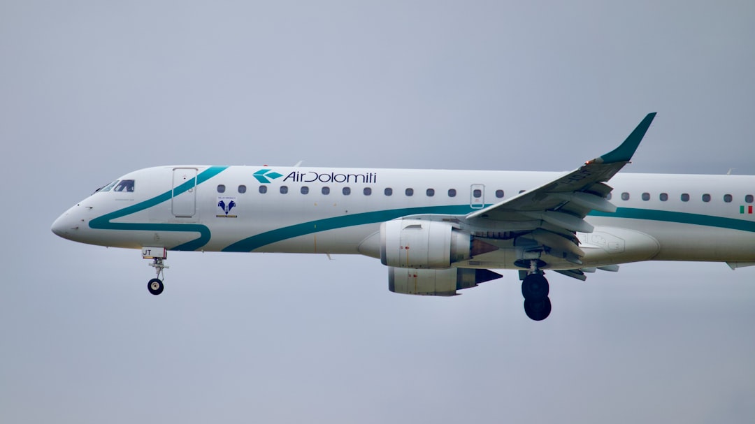 a large airplane flying in the sky, Air Dolomiti Embraer landing at Frankfurt Airport