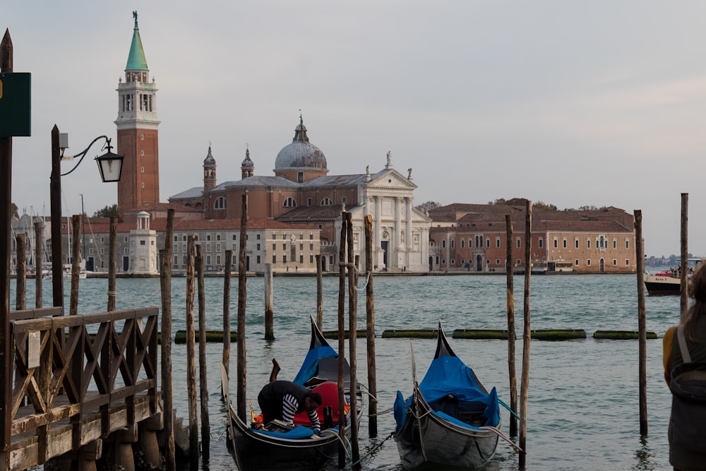 a group of boats in a body of water with buildings in the background