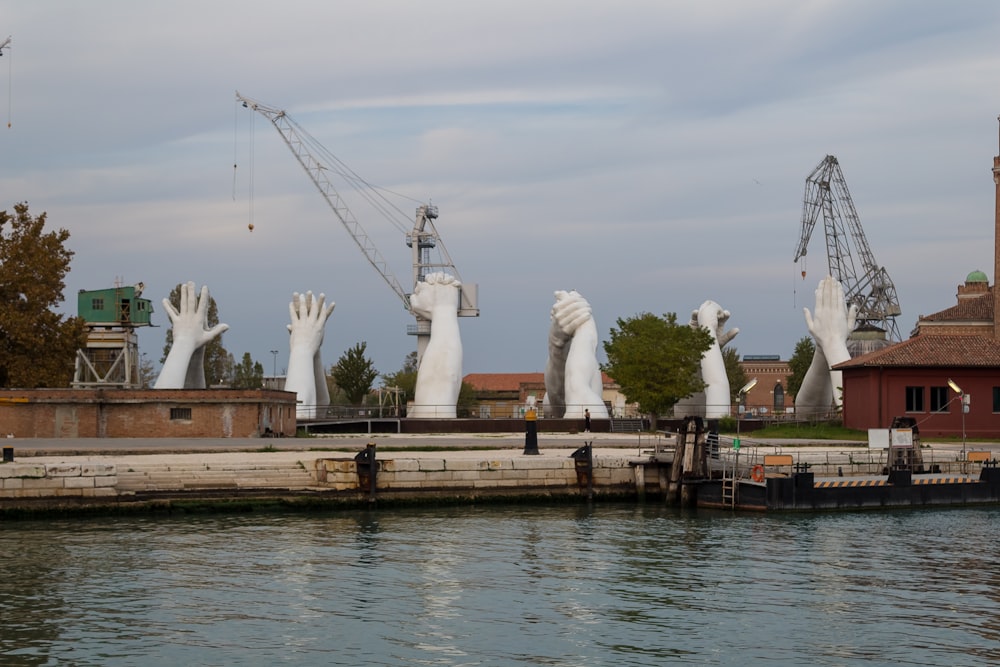 a body of water with a group of white statues and buildings around it