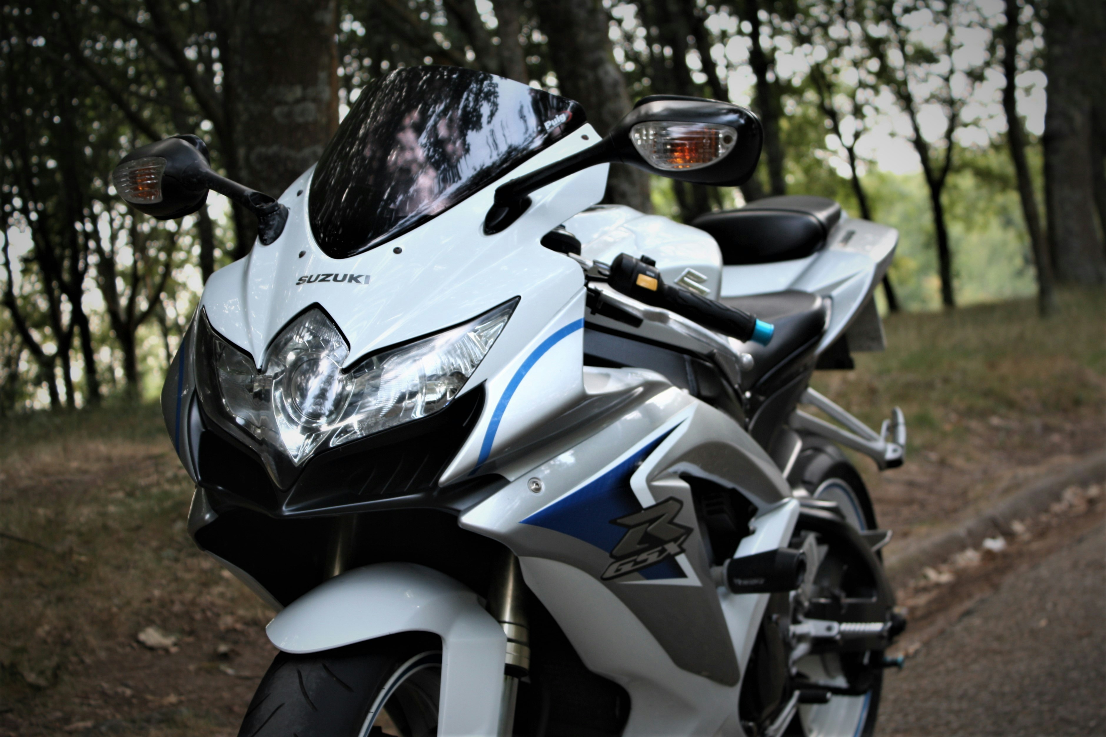 a white motorcycle parked on a dirt road