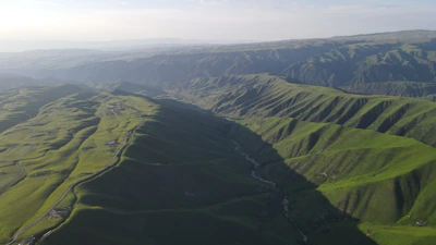 An aerial view of a spacious land parcel with rolling hills and distant mountains in Sri Lanka.