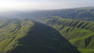 An aerial view of a spacious land parcel with rolling hills and distant mountains in Sri Lanka.