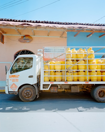 A large truck loaded with water tanks ready for delivery on a sunny day.
