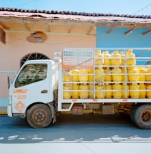 a truck with a lot of yellow containers on the back