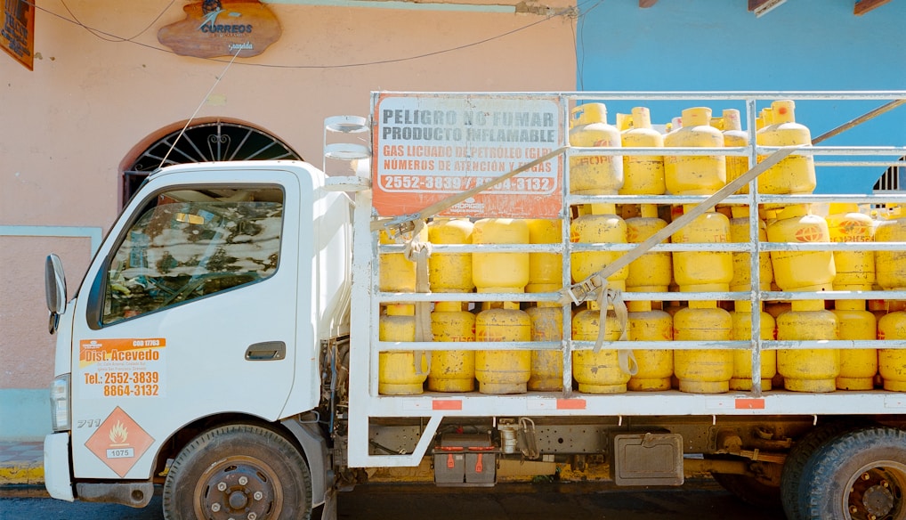 a truck with a lot of yellow containers on the back