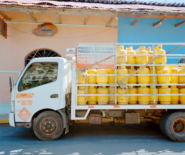 a truck with a lot of yellow containers on the back