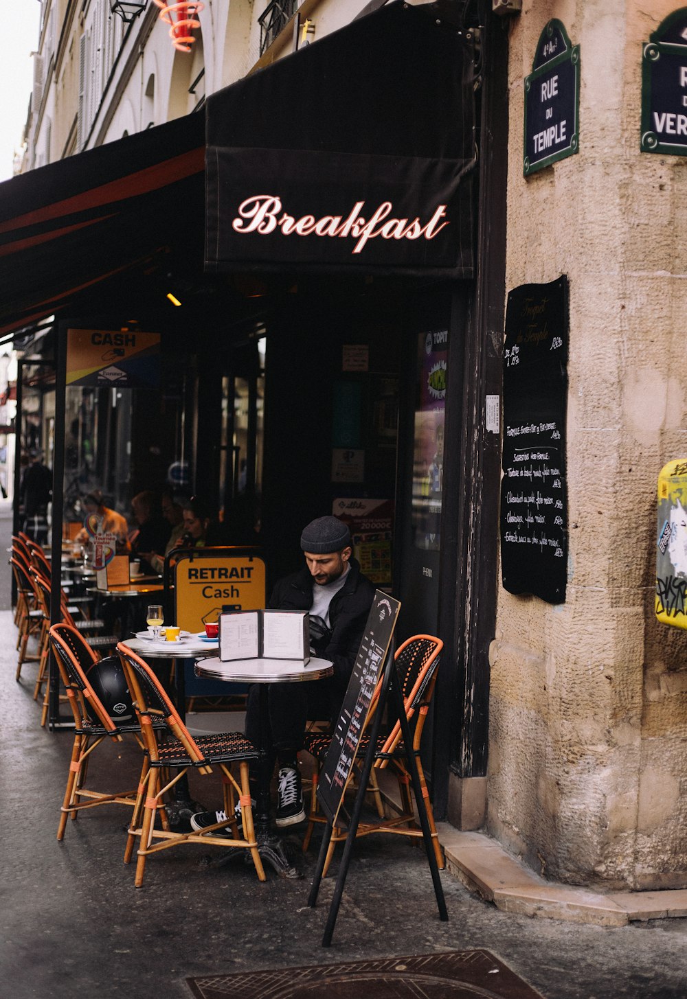 a person sitting at a table outside a restaurant