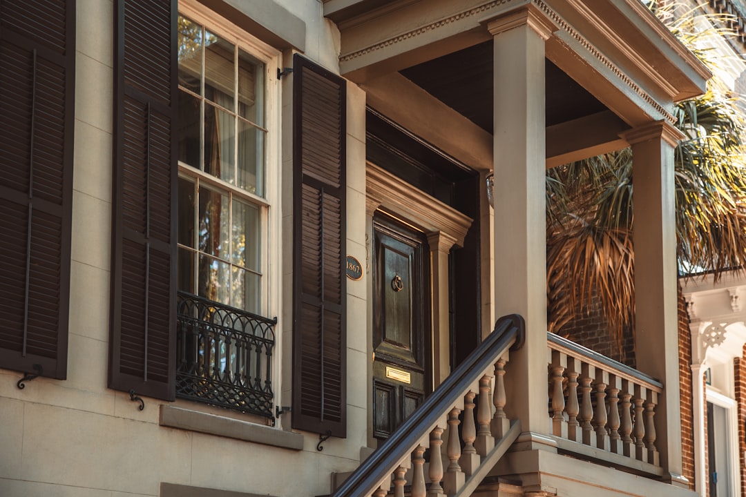 a building with a staircase and palm trees,