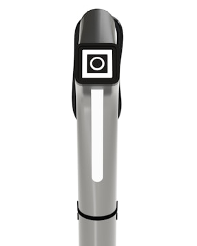 A sleek, vertical silver and black object with a rectangular digital display near the top. The display features a white circle within a square against a black background. The object has a modern, minimalistic design, possibly indicating a piece of technology or electronic equipment.