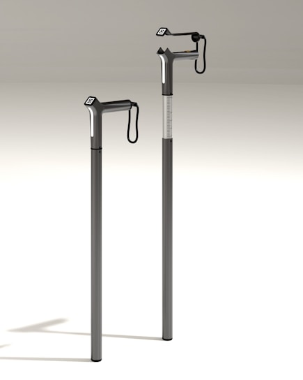 A close-up of a modern white cane with embedded technology, set against a blurred urban background.