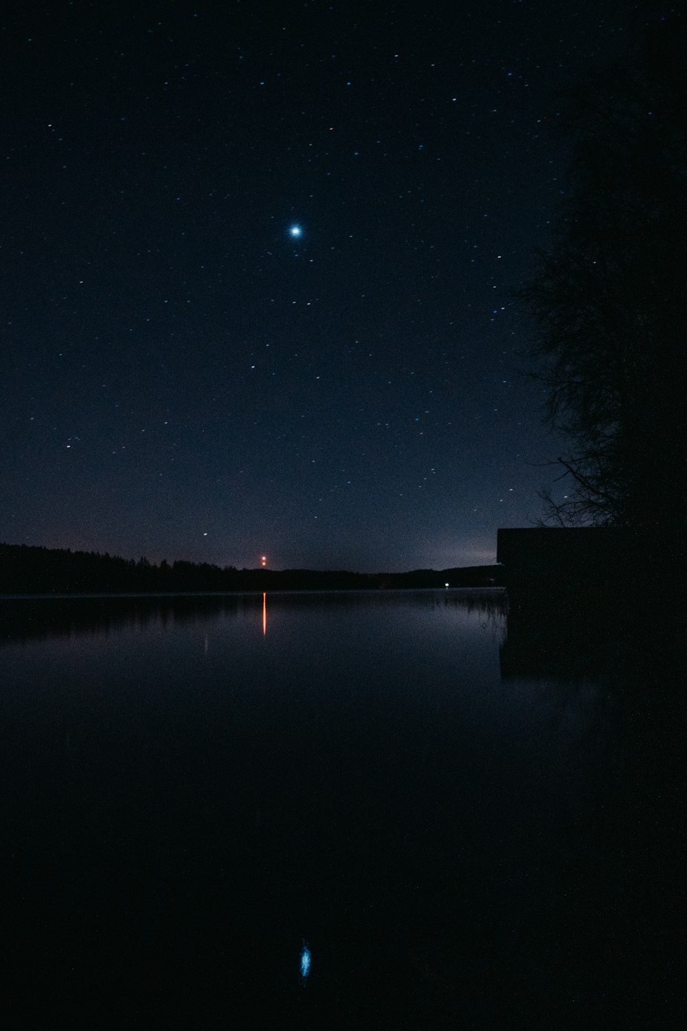 a body of water with a moon in the sky