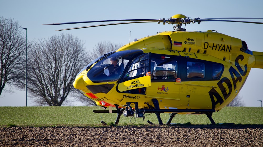 a yellow helicopter on grass