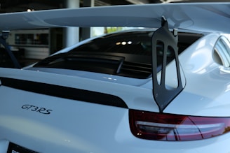 Rear view of the Porsche 911 GT3 with its distinctive spoiler and taillights illuminated.