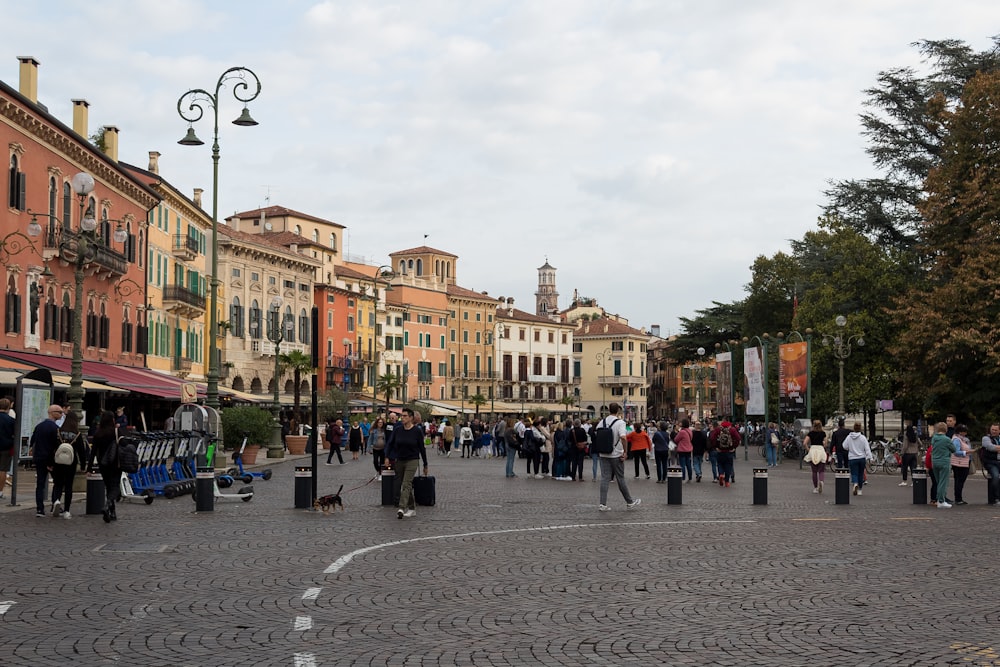 a group of people walking in a plaza with buildings in the background