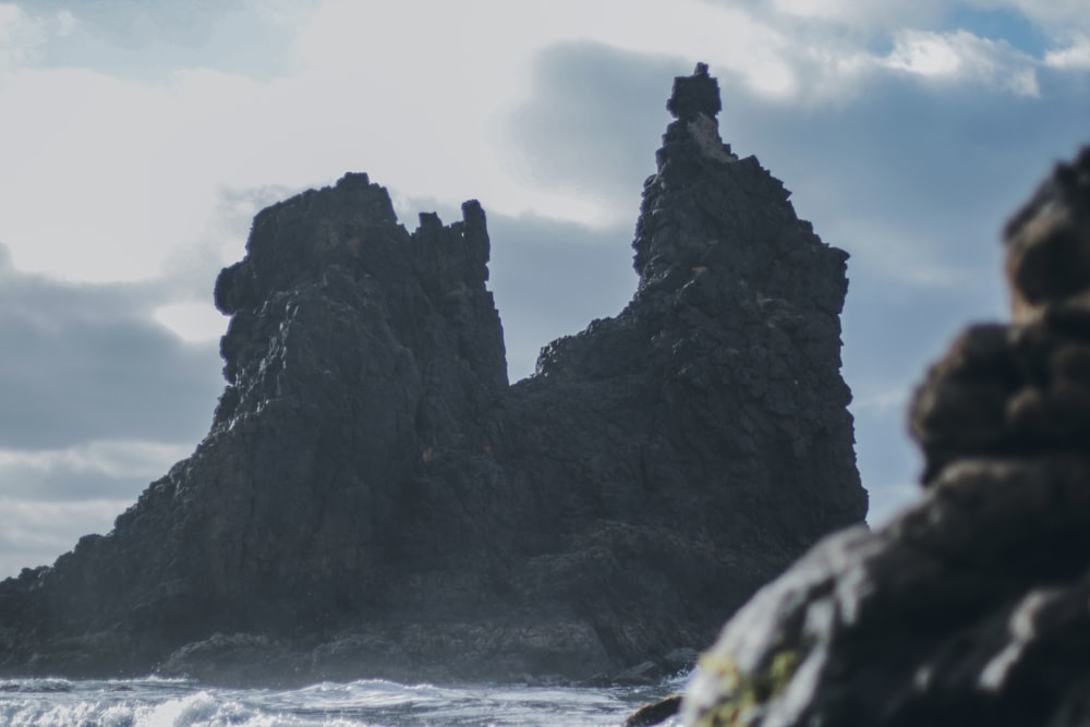 a rocky cliff with a body of water below