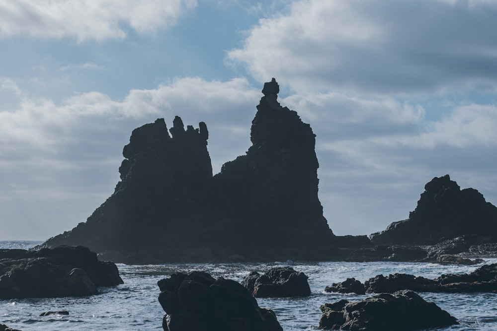 a rocky cliff with a body of water below