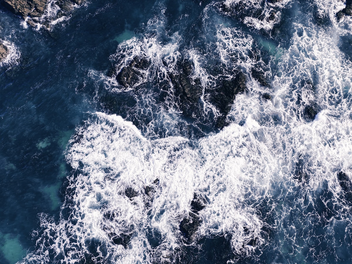 Dramatic aerial view of a Cornwall beach with turquoise water and golden sand