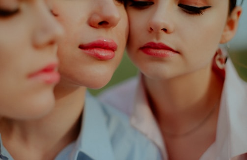 A diverse group of smiling women showcasing their makeup looks, each with radiant, smooth skin.