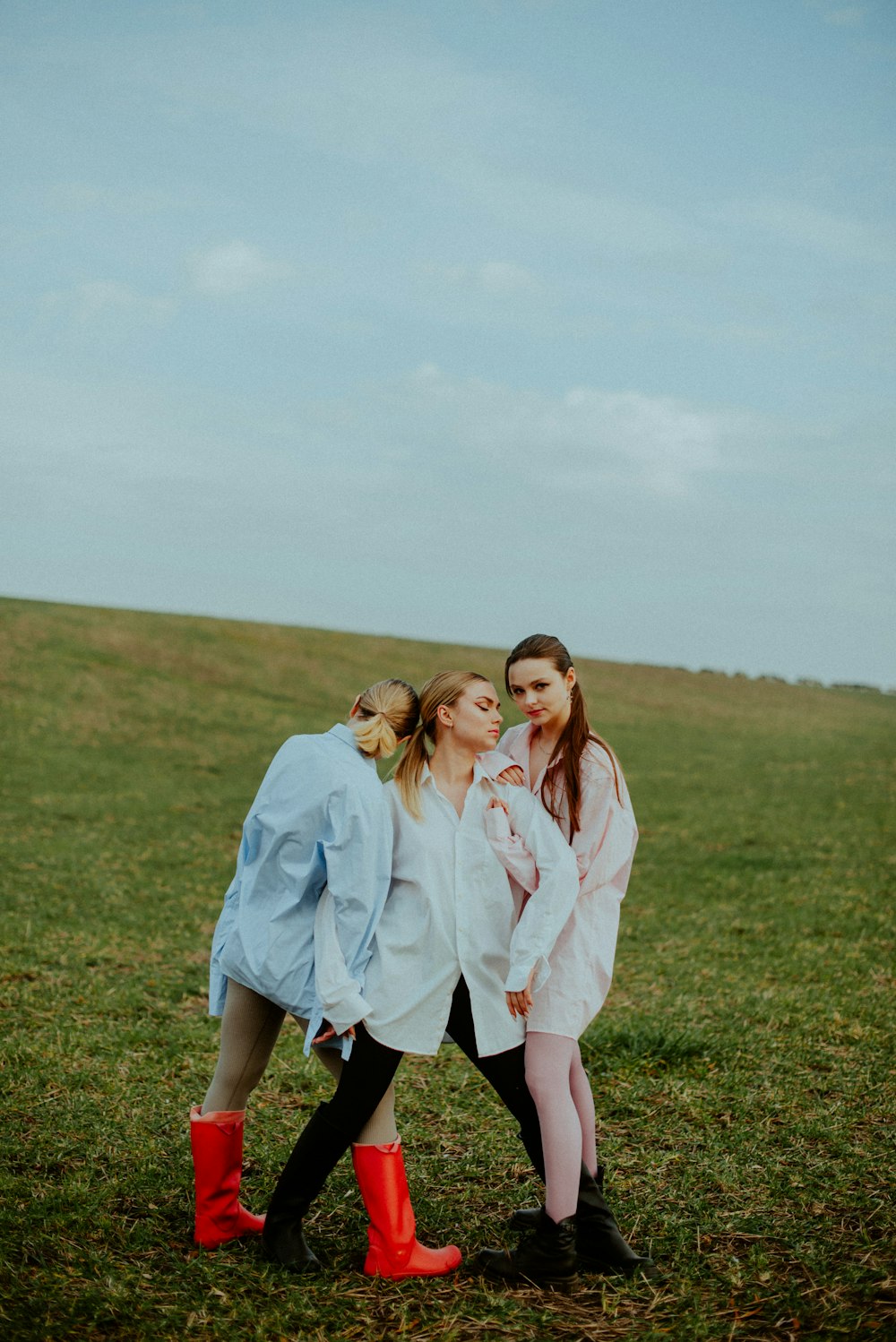 a group of women posing for a picture in a field