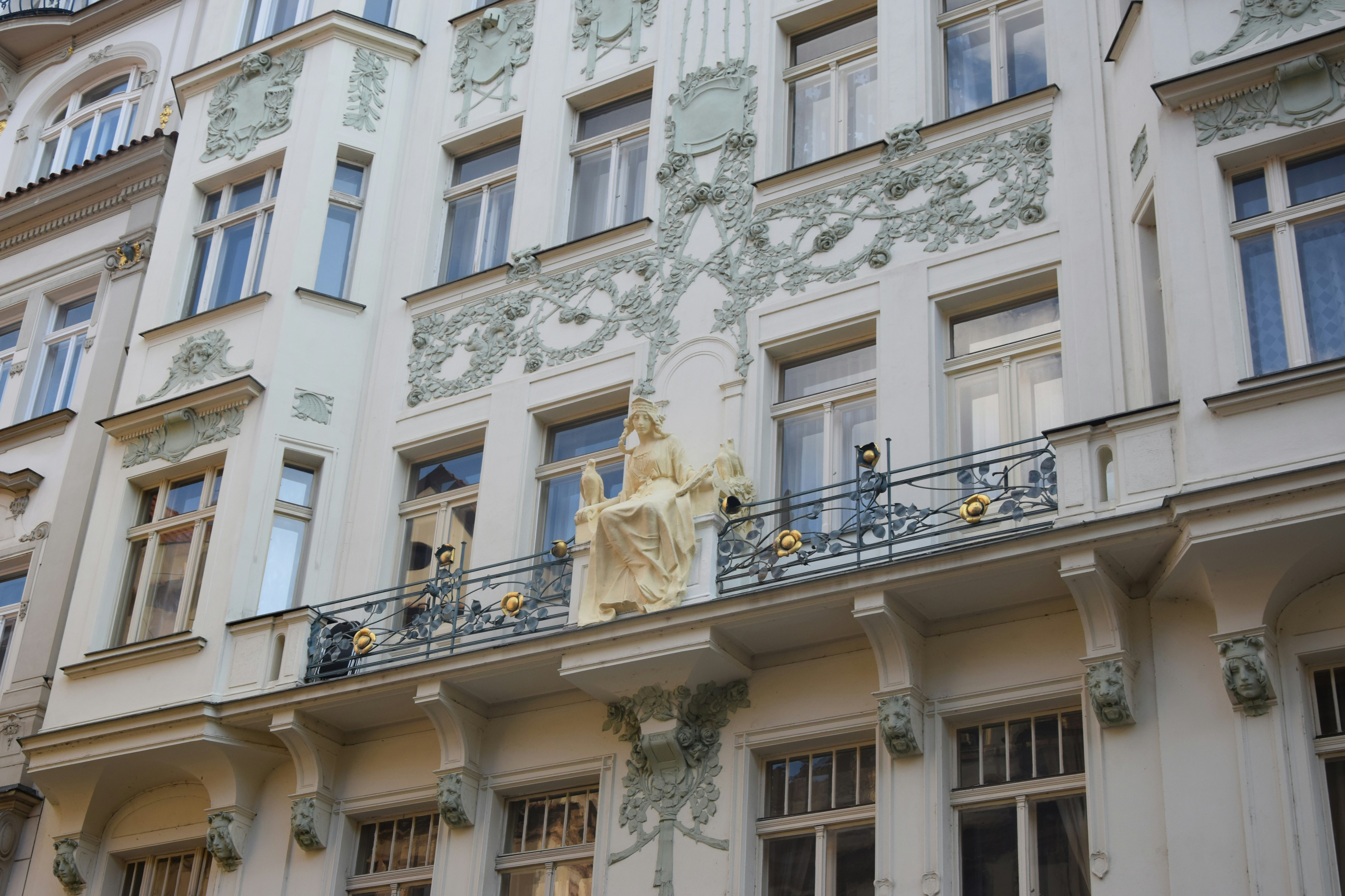 a building with a statue on the balcony