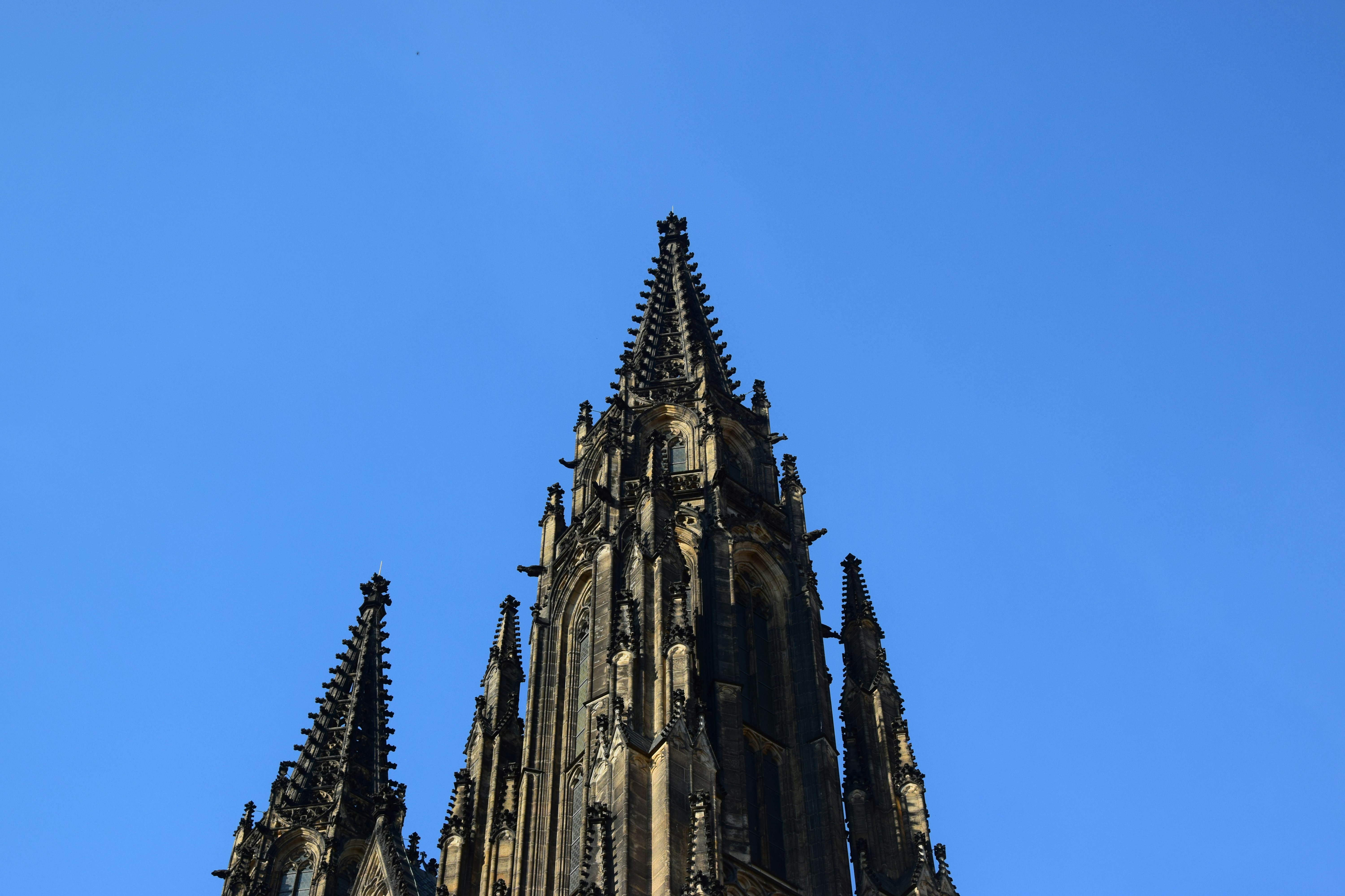 a tall building with pointy towers with Scott Monument in the background