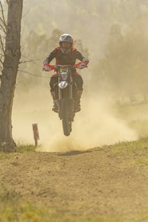 Close-up of a motocross rider mid-air during a jump on a dirt track.