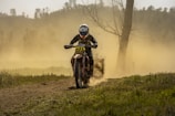 A rugged off-road motorbike kicking up dust on a mountain trail.
